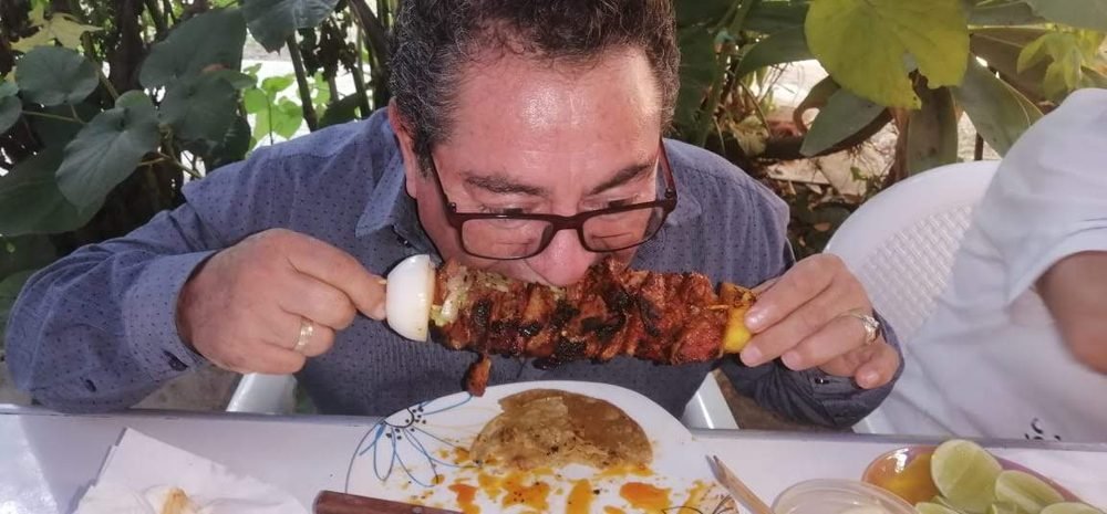 Un invitado disfrutando unas alitas en el evento